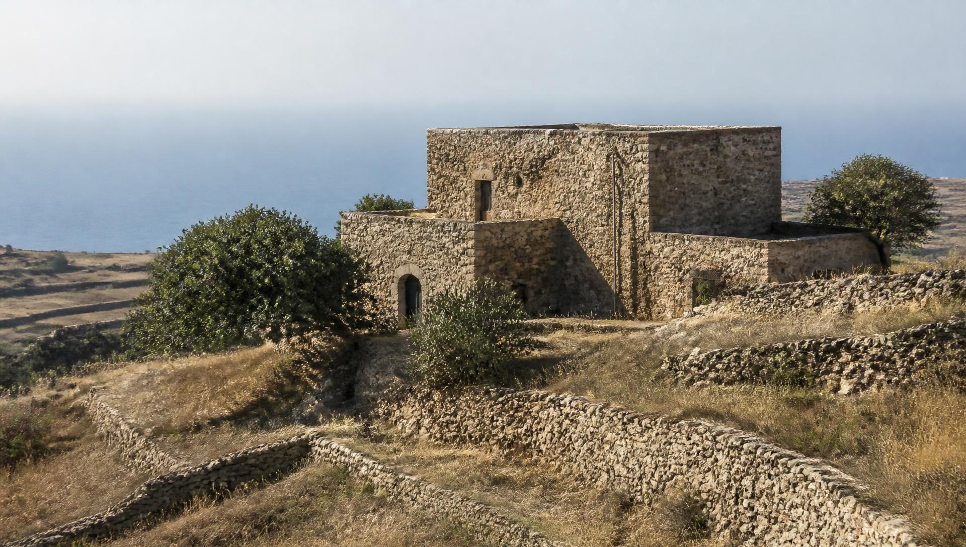 Casa de piedra vernácula sobre bancales aterrazados frente al mar Mediterráneo