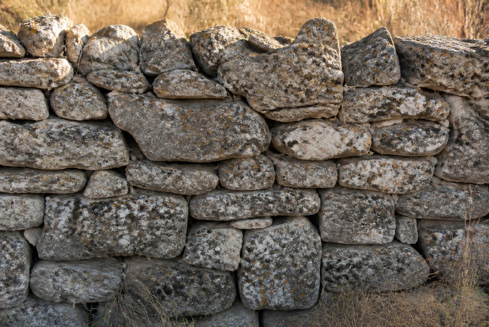 Muro de piedra seca de bloques calizos irregulares colocados sin mortero